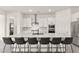 Modern white kitchen featuring a large marble waterfall island with seating for six at 31 Autumn Palm Ave, Henderson, NV 89011