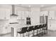Modern white kitchen featuring a large marble waterfall island with seating for six at 31 Autumn Palm Ave, Henderson, NV 89011