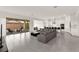 Open-concept living room with gray sectional, tile floors, and sliding glass doors to the backyard at 31 Autumn Palm Ave, Henderson, NV 89011