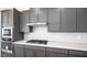 Modern kitchen with stainless steel appliances, gray cabinets, white backsplash and quartz countertops at 352 Tigullio Ave, Henderson, NV 89011