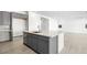 Open concept kitchen with gray cabinets, island sink, and spacious layout leading to the living area at 352 Tigullio Ave, Henderson, NV 89011