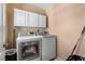 A bright laundry room with white washer and dryer units and white storage cabinets at 10437 Walworth Ave, Las Vegas, NV 89166