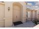 Charming front entry with arched doorway, stucco walls, and desert landscaping at 2691 Rimpacific Cir, Las Vegas, NV 89146