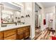 Bright bathroom featuring a wood vanity, double sinks, and a glass-enclosed shower at 3665 Cottage Stone Ct, Laughlin, NV 89029