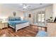 Well-lit primary bedroom with hardwood flooring, a whitewashed bed frame, and large windows at 3665 Cottage Stone Ct, Laughlin, NV 89029