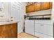 Functional laundry room with washer, dryer, storage cabinets, and a utility sink at 3665 Cottage Stone Ct, Laughlin, NV 89029