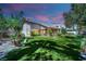Expansive backyard features a lush lawn, mature trees, desert landscaping, and a covered patio for outdoor living at 4722 Blue Mesa Way, Las Vegas, NV 89129