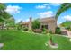 Spacious backyard featuring a lush lawn, mature landscaping, and a charming single-story home at 4722 Blue Mesa Way, Las Vegas, NV 89129
