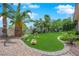 Professionally landscaped backyard featuring lush turf, desert flora, rock accents, and gravel borders at 4722 Blue Mesa Way, Las Vegas, NV 89129