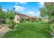 Large grassy backyard featuring mature trees, lush landscaping, and a well-manicured lawn at 4722 Blue Mesa Way, Las Vegas, NV 89129