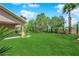 Spacious backyard featuring manicured artificial turf, trees, and manicured landscaping at 4722 Blue Mesa Way, Las Vegas, NV 89129