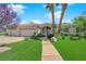 Single-story home features a three-car garage, desert landscaping, mature shade trees, and well-maintained lawn at 4722 Blue Mesa Way, Las Vegas, NV 89129