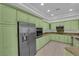 Spacious kitchen with green cabinets, granite countertops, and stainless steel appliances at 4722 Blue Mesa Way, Las Vegas, NV 89129