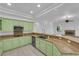 Bright kitchen featuring custom green cabinets and breakfast bar open to the living room with fireplace at 4722 Blue Mesa Way, Las Vegas, NV 89129