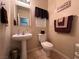 Cozy bathroom featuring a pedestal sink, tile flooring, and warm, neutral tones at 6080 Golden Corral Trl # 103, Henderson, NV 89011