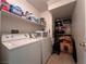 Functional laundry room featuring white washer and dryer with shelving for storage at 6080 Golden Corral Trl # 103, Henderson, NV 89011