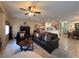 Cozy living room featuring tile flooring, comfortable furniture, and an open dining area at 6080 Golden Corral Trl # 103, Henderson, NV 89011