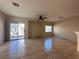 Open-concept living room showcasing tiled flooring, a ceiling fan, and sliding glass doors at 6080 Golden Corral Trl # 103, Henderson, NV 89011