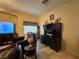 Comfortable living room featuring tile floors, a workstation, a comfortable chair and a TV at 6080 Golden Corral Trl # 103, Henderson, NV 89011