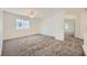 Spacious carpeted room with a ceiling fan and two windows providing natural light at 8447 Amherst Valley St, Las Vegas, NV 89123