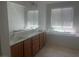 Bathroom featuring double sinks, a bathtub, and plenty of natural light from the windows at 8584 Garnet Lake Ave, Las Vegas, NV 89113