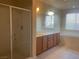Bathroom with a glass shower, large mirror, double sinks, a bathtub, and natural light at 8584 Garnet Lake Ave, Las Vegas, NV 89113