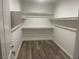 A walk-in closet with installed shelving and wood-look floors at 8584 Garnet Lake Ave, Las Vegas, NV 89113