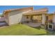 Backyard features a covered patio, lush lawn, and privacy fencing at 100 Underhill Ct, Las Vegas, NV 89145