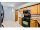 Well-lit kitchen boasts wooden cabinetry, modern appliances, and tile floors at 100 Underhill Ct, Las Vegas, NV 89145