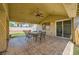 Covered patio boasts tile floor, a fan, and views of the well-maintained yard at 100 Underhill Ct, Las Vegas, NV 89145