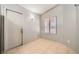 Neutral room featuring tile floors, a window with blinds, and a door, providing ample natural light at 100 Underhill Ct, Las Vegas, NV 89145