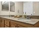 Bathroom vanity with double sinks, granite counters, and wood cabinetry offers style and convenience at 10550 W Alexander Rd # 2103, Las Vegas, NV 89129