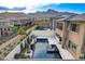 Expansive backyard featuring a modern pool, spa, outdoor kitchen, and water feature with mountain views in the background at 12439 Iron Bluff Ave, Las Vegas, NV 89138