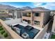 Beautiful backyard featuring a modern pool, spa, water feature, outdoor kitchen, and lush landscaping at 12439 Iron Bluff Ave, Las Vegas, NV 89138