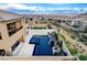 Stunning aerial view of a backyard featuring a modern pool, spa, water feature, and a seating area at 12439 Iron Bluff Ave, Las Vegas, NV 89138