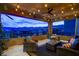 This outdoor balcony features stunning landscape views with comfortable seating and string lights at 12439 Iron Bluff Ave, Las Vegas, NV 89138