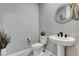 Stylish powder room featuring a pedestal sink, decorative mirror, and neutral color palette that creates a modern, chic space at 12439 Iron Bluff Ave, Las Vegas, NV 89138