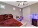 This bedroom features carpeted floors, a ceiling fan, a work space, and a sliding-door closet at 12439 Iron Bluff Ave, Las Vegas, NV 89138