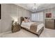 This bedroom features neutral decor, a decorative chandelier, and plantation shutters at 12439 Iron Bluff Ave, Las Vegas, NV 89138
