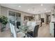 Dining area features a modern glass table, stylish chairs, and seamless access to the outdoor patio and kitchen at 12439 Iron Bluff Ave, Las Vegas, NV 89138
