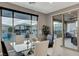 Dining area with a glass table, modern chairs, and a view of the pool and backyard amenities at 12439 Iron Bluff Ave, Las Vegas, NV 89138