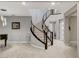 Elegant foyer with curved staircase, modern railing, wood-look tile floors, and stylish lighting at 12439 Iron Bluff Ave, Las Vegas, NV 89138