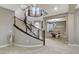 Stylish foyer featuring curved staircase, modern railings, tile floors, and access to a game room at 12439 Iron Bluff Ave, Las Vegas, NV 89138