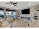 Cozy living room features a modern fireplace, mounted TV, and sliding doors leading to the outdoor living area at 12439 Iron Bluff Ave, Las Vegas, NV 89138