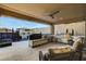 Stylish outdoor kitchen with a built-in grill, sink, and seating area, next to the beautiful pool and waterfall feature at 12439 Iron Bluff Ave, Las Vegas, NV 89138