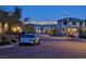 Residential street view featuring a modern blue car parked near homes with city lights in the background at 12439 Iron Bluff Ave, Las Vegas, NV 89138