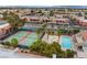 An aerial view shows community tennis courts and pool with palm trees and mountain views in the background at 4421 Alexis Dr # 429, Las Vegas, NV 89103