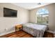 Cozy bedroom with wood floors, large window, and wall-mounted television at 10235 Headrick Dr, Las Vegas, NV 89166