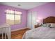 Bright bedroom with hardwood floors, a window with blinds, and a cozy bed at 10235 Headrick Dr, Las Vegas, NV 89166