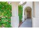 Arched entryway leading to the front door, framed by lush greenery and textured stucco pillars at 10235 Headrick Dr, Las Vegas, NV 89166